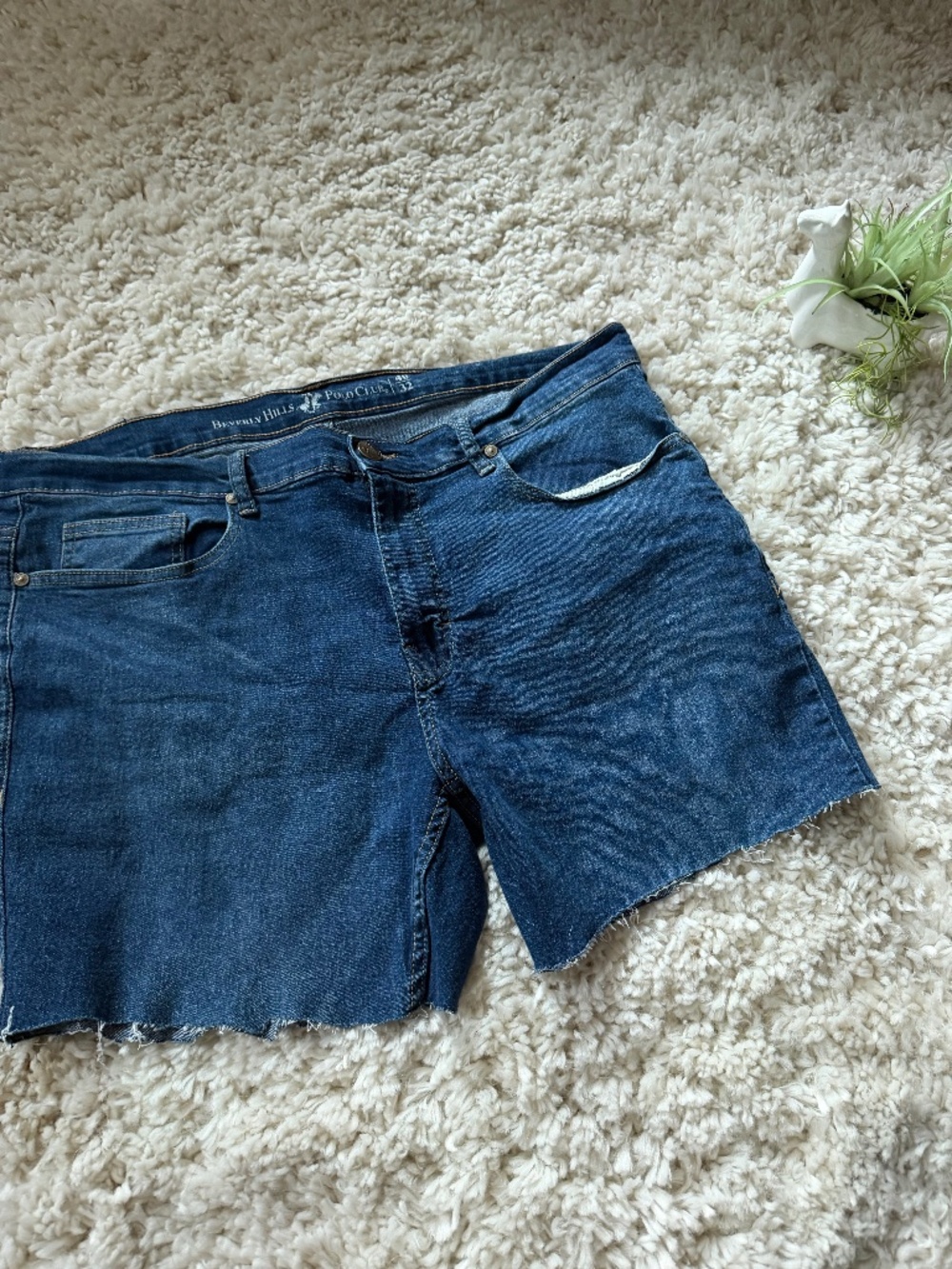 Dark blue denim cutoffs with raw frayed hem. Classic five-pocket styling. Comfor